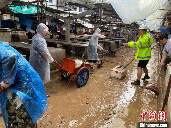 圖為7月26日，暴雨引發(fā)的洪水過境后，重慶萬州區(qū)分水鎮(zhèn)政府干部職工及志愿者清掃淤泥和垃圾?！　≈貞c萬州區(qū)委宣傳部供圖 攝